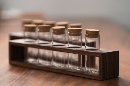 empty walnut holder with glass tubes for spices on walnut table surface, shallow focus