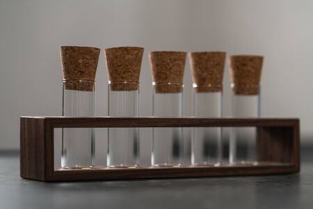Empty walnut holder with glass tubes for spices on concrete surfaceの写真素材