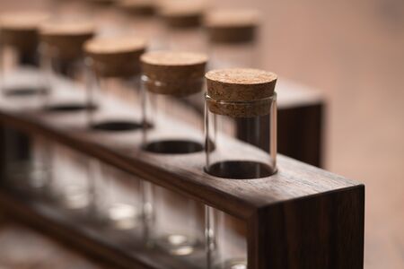 empty walnut holder with glass tubes for spices on walnut table surface, shallow focusの写真素材