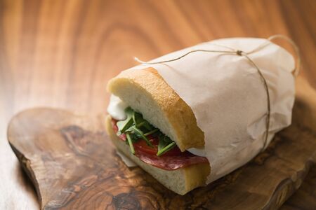 ciabatta sandwich with salami and mozzarella cheese on walnut table, shallow focusの写真素材