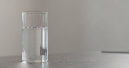 clean fresh water in beaker glass on concrete countertop