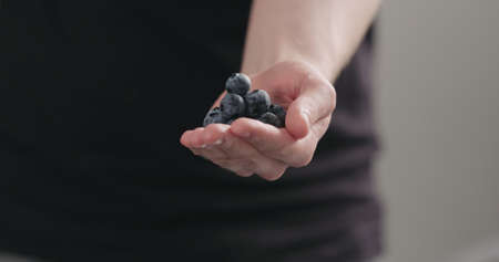 man hand show big ripe blueberriesの写真素材