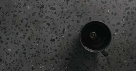 black coffee in black cup on concrete background top view