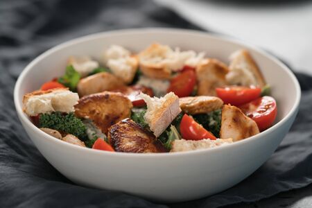 Caesar salad alternative with kale and turkey in white bowl, shallow focusの写真素材