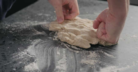 man working with dough on concrete countertopの写真素材
