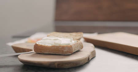 cream cheese over ciabatta to make sandwich on wood boardの写真素材