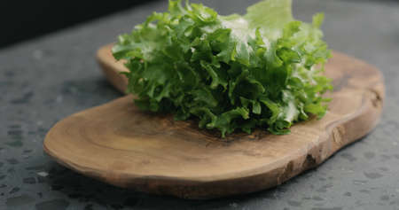 frisee salad leaves on olive board