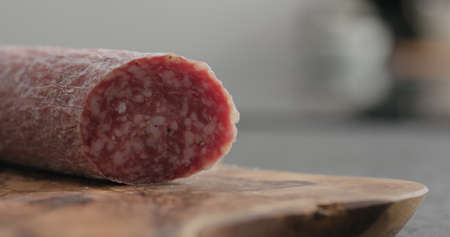 sliced salame sausage on olive wood board