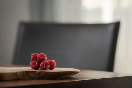 ripe raspberry on a olive wood board with copy spaceの写真素材