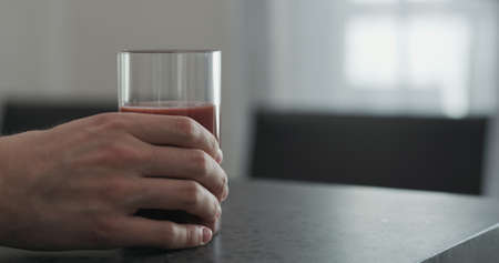man hand take smoothie in highball glass on concrete countertop