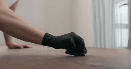 man hand applying oil finish to toned walnut table with clothの写真素材