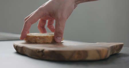 man hand put ciabatta slice on olive board