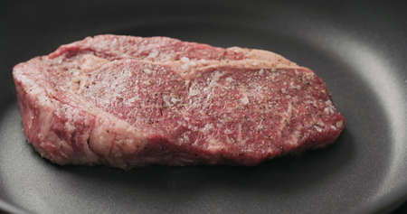 Closeup shot of ribeye steak frying on non stick panの写真素材