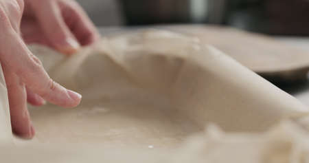 man hand spread oil in container with baking paper