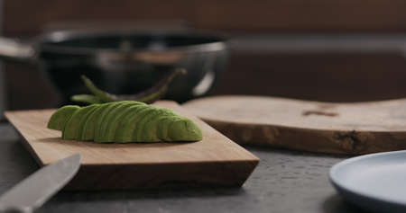 sliced avocado on olive wood board