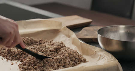 Slow motion making granola, spread on baking sheetの写真素材