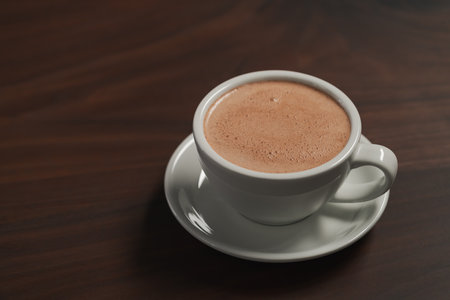 Cup of hot cocoa drink on walnut wood tableの写真素材