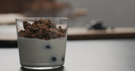 granola with blueberries in glass with copy space
