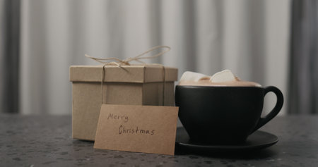 gift box near black cup with hot chocolate on concrete countertopの写真素材