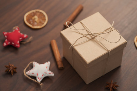 Christmas gift box from eco friendly paper wrapped with natural twine on wood table with natural decorationsの写真素材