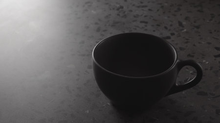 black cup on concrete countertop with copy space under dim lightの写真素材