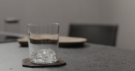 ice into tumbler glass on concrete countertopの写真素材