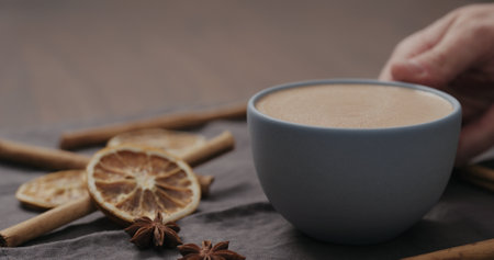 closeup man hand take cocoa drink in blue cup from walnut table with christmas decorations and copy spaceの写真素材
