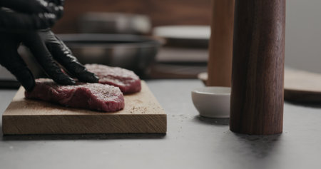man rub seasoning into raw beef steak on oak boardの写真素材