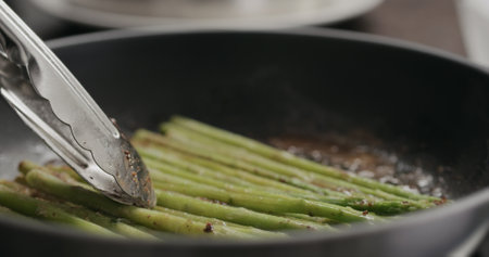 closeup of frozen asparagus cooking on nonstick panの写真素材