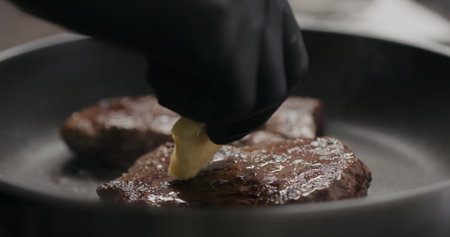 man rub butter on beef steak on nonstick panの写真素材