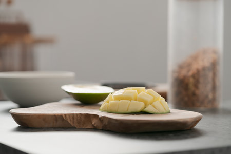 Ripe green mango sliced on olive wood boardの写真素材