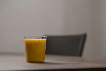 Mango lulo smoothie on walnut wood table with copy spaceの写真素材