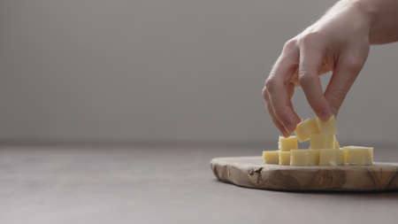 man hand arrange vintage hard cheese pieces on olive wood boardの写真素材