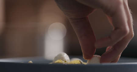 Add mozzarella balls to pesto fettuccine in blue bowl closeup