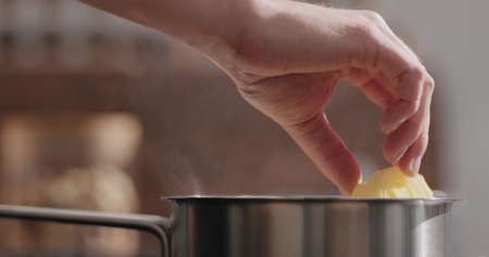 man hand put fettuccine pasta in saucepan with boiling water closeupの写真素材