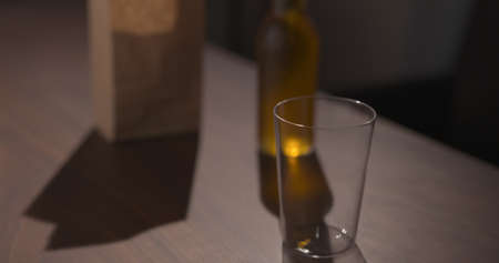 amber color fizzy drink in tumbler glass with bag of potato chips on backgroundの写真素材