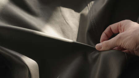 Man hand touching soft leather with sun shining from a window