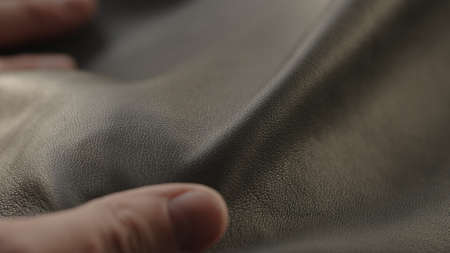 Man hand touching soft leather with sun shining from a window