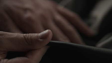 Man hand touching soft leather with sun shining from a windowの写真素材