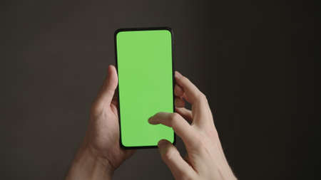 POV top view shot of man using phone with green screen indoorの写真素材