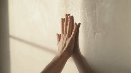 man playing with sunlight indoor next to wallの写真素材