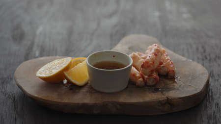 crab leg meat on a olive board with sweet lemonの写真素材
