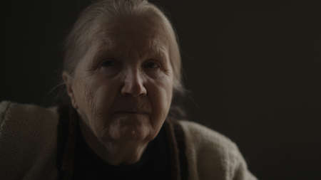 Senior woman sitting indoor with soft window light