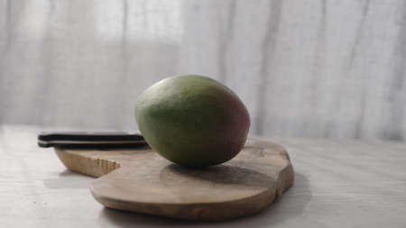 fresh ripe mango on olive board