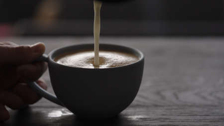 pour streamed milk into blue cup to make cappuccino with copy spaceの写真素材