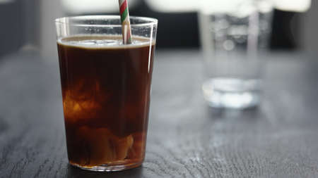 Making espresso tonic in tumbler with ice ballの写真素材