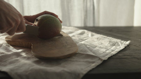 man cut ripe mango on olive wood boardの写真素材