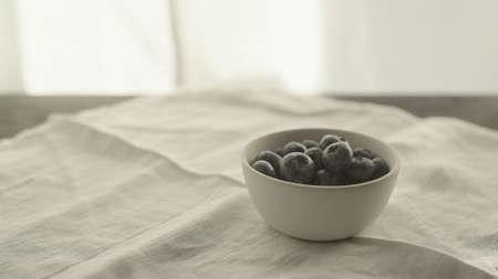 fresh blueberries in white bowl on linen napkinの写真素材