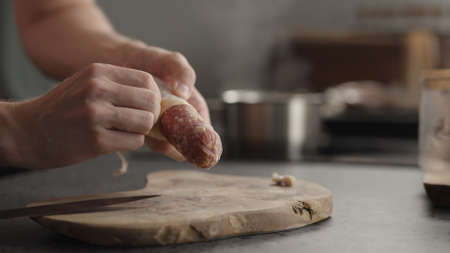 man peel cured sausage before slicingの写真素材