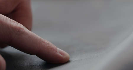 closeup man hand checking soft gray leather clothesの写真素材